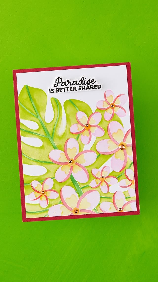 From stencil to tropical masterpiece! 🌺 Watch June’s Stencil Club Plumeria Spray come to life with layered color, lush monstera leaves, and dreamy island blooms. The finishing touch? A sentiment that says it all: Paradise is better shared! 💕🌴 #SpellbindersClub #StencilClub #Cardmaking by @teamspellbinders